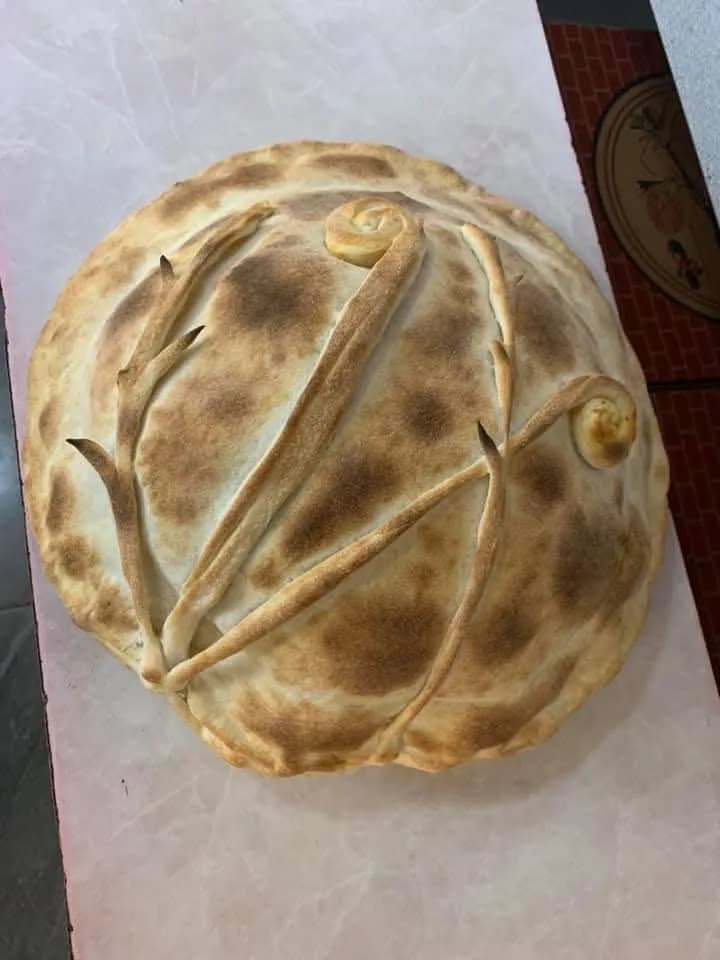 Färdigbakad rund inbakad pizza med vacker bruning och dekorativt deg-mönster — Kärna Pizzeria